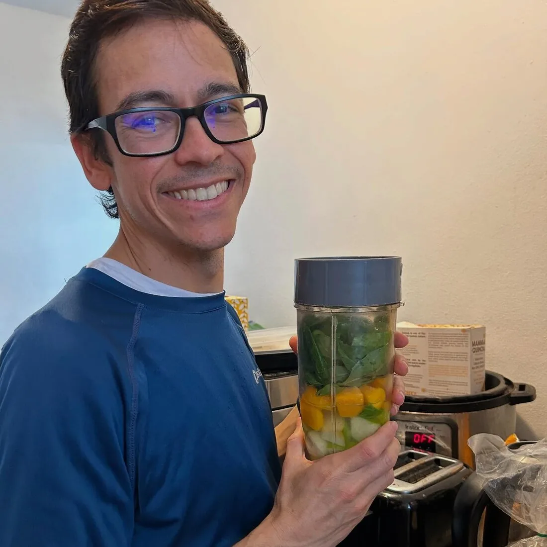 Dr. Giomarell holding a blender of fresh smoothie ingredients during an online event